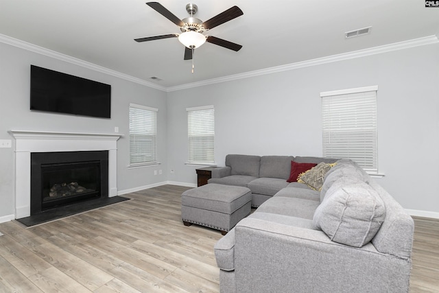 living room with ornamental molding, ceiling fan, and light hardwood / wood-style flooring