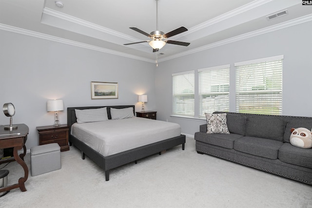 bedroom featuring crown molding, ceiling fan, a tray ceiling, and light colored carpet