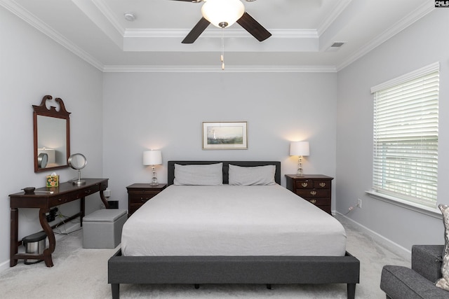 carpeted bedroom featuring ornamental molding, ceiling fan, and a tray ceiling