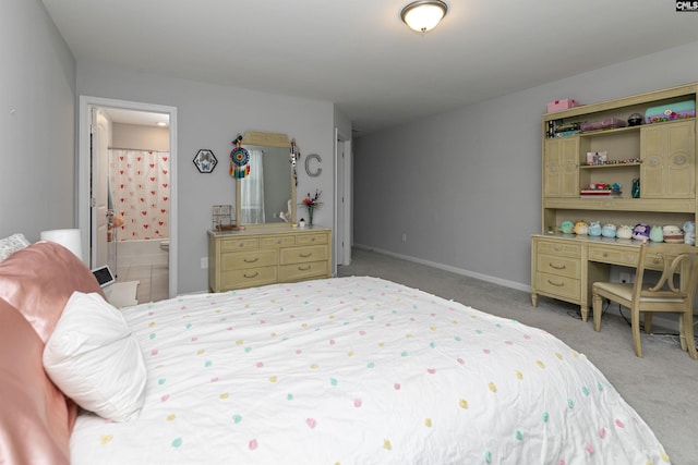 bedroom featuring ensuite bath and carpet