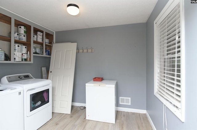 laundry room featuring washing machine and dryer and light wood-type flooring