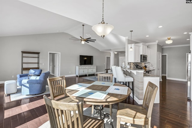 dining room featuring lofted ceiling, ornamental molding, dark hardwood / wood-style flooring, ceiling fan, and decorative columns