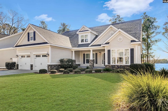 craftsman-style home with a garage, a front yard, and a porch