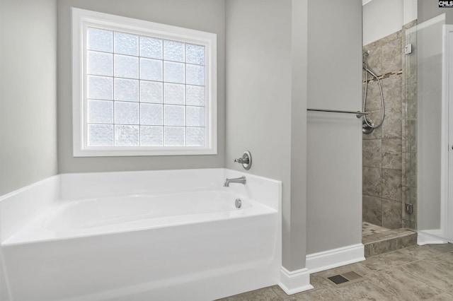 bathroom with tile patterned floors and independent shower and bath