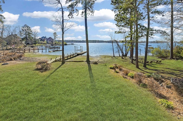 view of yard featuring a water view and a dock