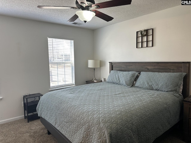 carpeted bedroom featuring ceiling fan and a textured ceiling