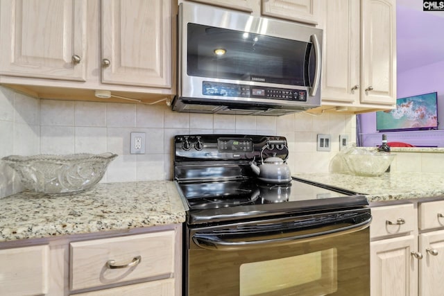 kitchen with light stone countertops, light brown cabinets, electric range, and backsplash