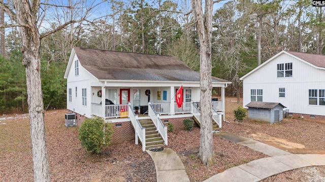 view of front of house with central AC unit, covered porch, and a storage unit