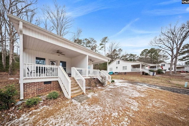 view of snowy exterior with ceiling fan and covered porch