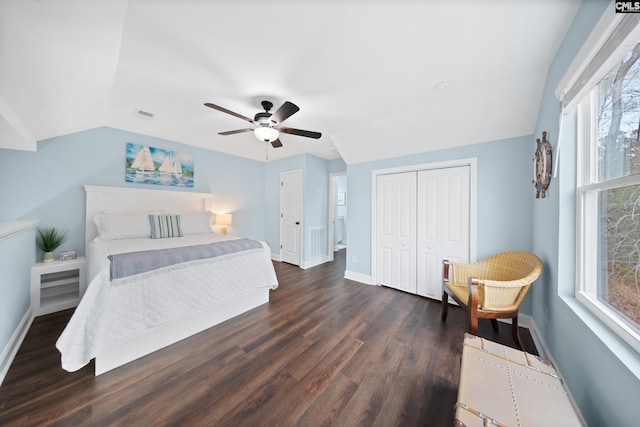 bedroom featuring dark hardwood / wood-style flooring, vaulted ceiling, a closet, and ceiling fan