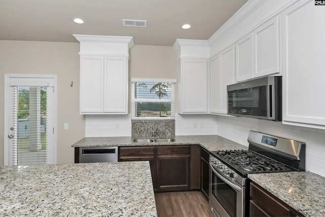 kitchen with white cabinetry, sink, dark brown cabinetry, and appliances with stainless steel finishes