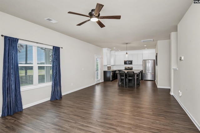 unfurnished living room with dark wood-type flooring and ceiling fan