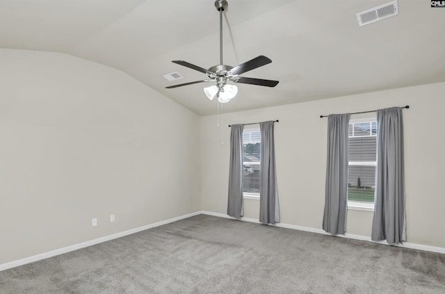 spare room with ceiling fan, light colored carpet, and vaulted ceiling