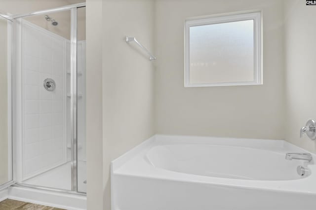 bathroom featuring shower with separate bathtub