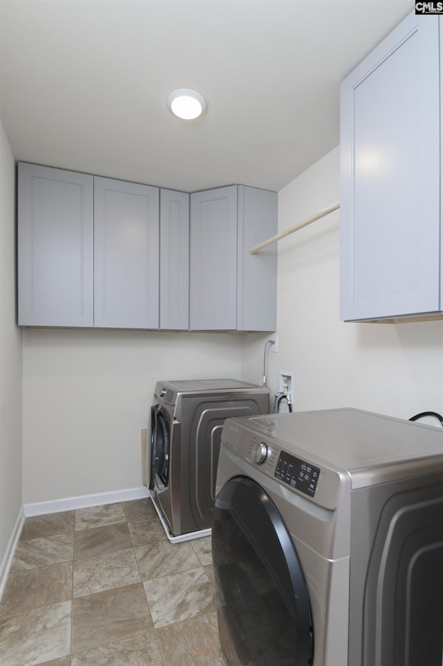 laundry room with separate washer and dryer and cabinets