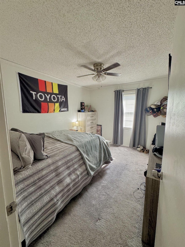 bedroom featuring ceiling fan, carpet, and a textured ceiling