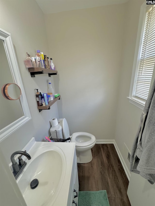 bathroom with vanity, toilet, and hardwood / wood-style floors