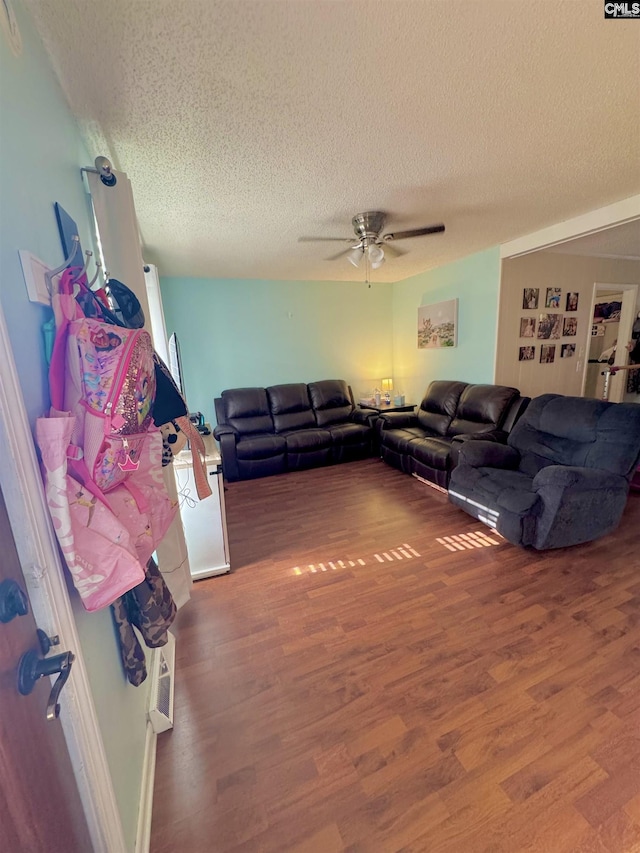 living room featuring hardwood / wood-style floors, a textured ceiling, and ceiling fan