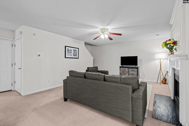 living room featuring light carpet, a textured ceiling, and ceiling fan