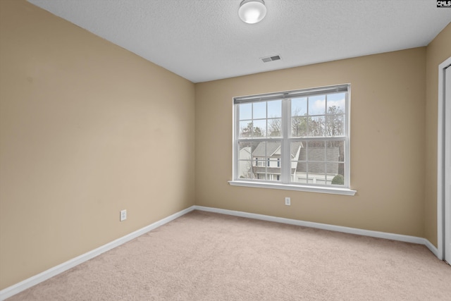 carpeted spare room with a textured ceiling