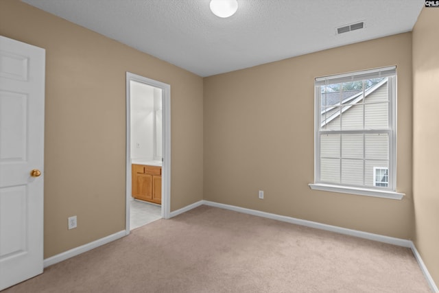 carpeted spare room with a textured ceiling