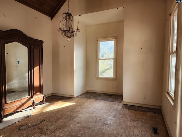 empty room featuring vaulted ceiling, wood ceiling, and a chandelier