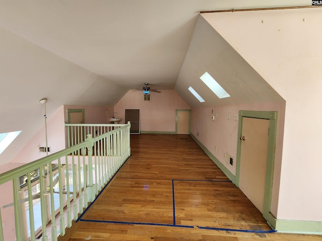 bonus room with hardwood / wood-style floors, vaulted ceiling with skylight, and ceiling fan