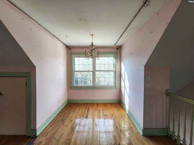 additional living space featuring light hardwood / wood-style floors and a chandelier