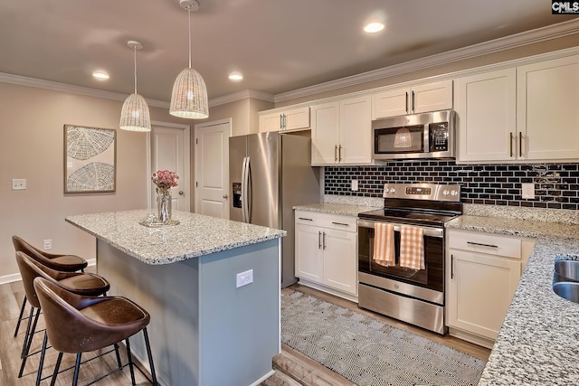 kitchen with light stone counters, appliances with stainless steel finishes, decorative light fixtures, and backsplash