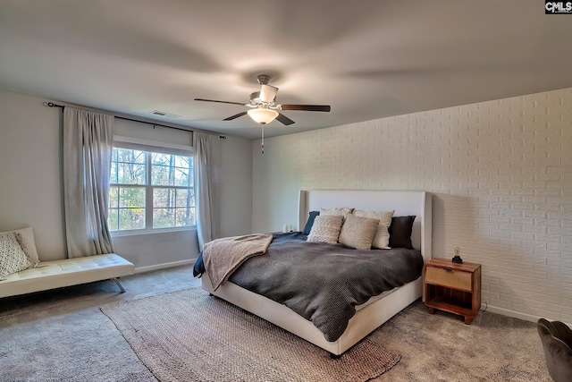 bedroom with ceiling fan, brick wall, and carpet floors