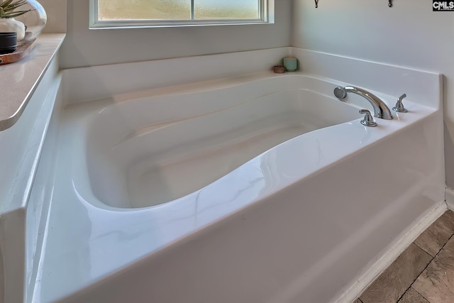 bathroom featuring tile patterned floors and a bath