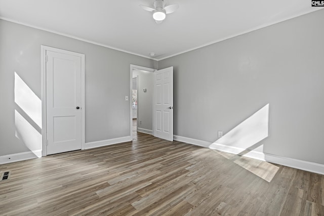 spare room featuring hardwood / wood-style flooring, ornamental molding, and ceiling fan