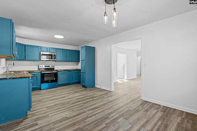 kitchen featuring blue cabinets, sink, crown molding, decorative light fixtures, and appliances with stainless steel finishes