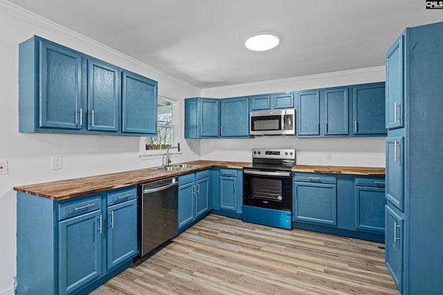 kitchen featuring blue cabinets, appliances with stainless steel finishes, and butcher block counters