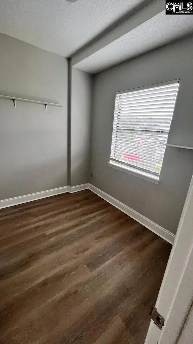 spare room with dark wood-type flooring and a textured ceiling