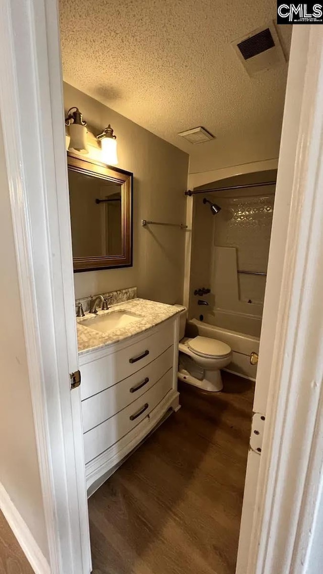 full bathroom with vanity, a textured ceiling, wood-type flooring, and toilet