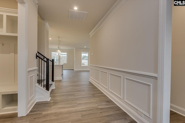 corridor with ornamental molding and light wood-type flooring