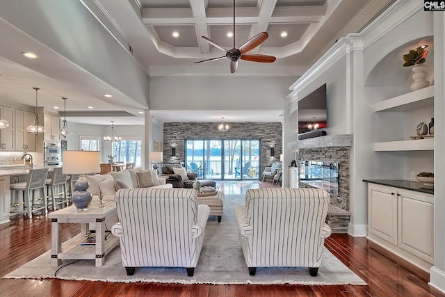 living room featuring crown molding, coffered ceiling, a stone fireplace, and dark hardwood / wood-style flooring