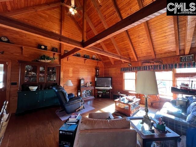 living room with beamed ceiling, wooden ceiling, wood-type flooring, and wood walls