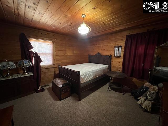 bedroom featuring wood ceiling, wooden walls, and carpet floors