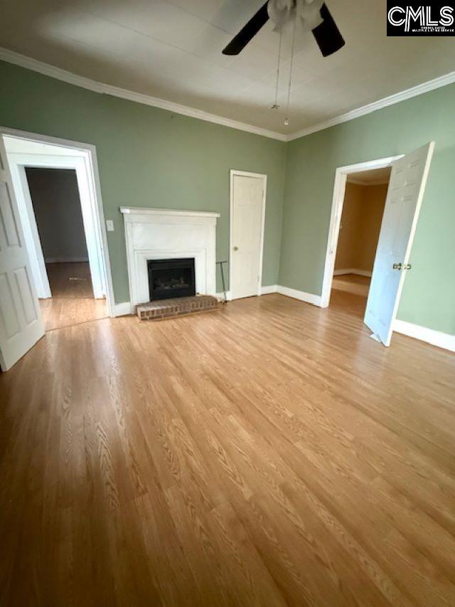 unfurnished living room featuring ornamental molding, light hardwood / wood-style floors, and ceiling fan