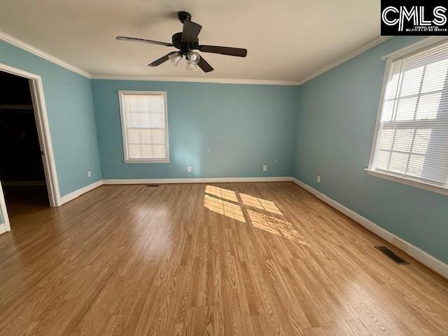 unfurnished room featuring hardwood / wood-style floors, crown molding, and ceiling fan