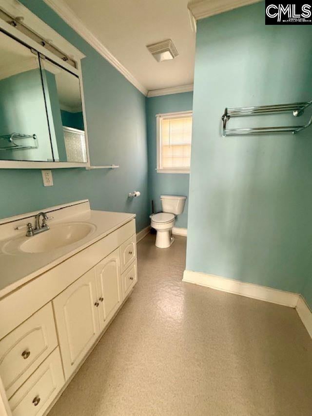 bathroom with ornamental molding, vanity, and toilet