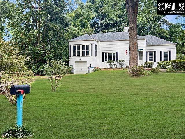 back of house featuring a garage and a lawn