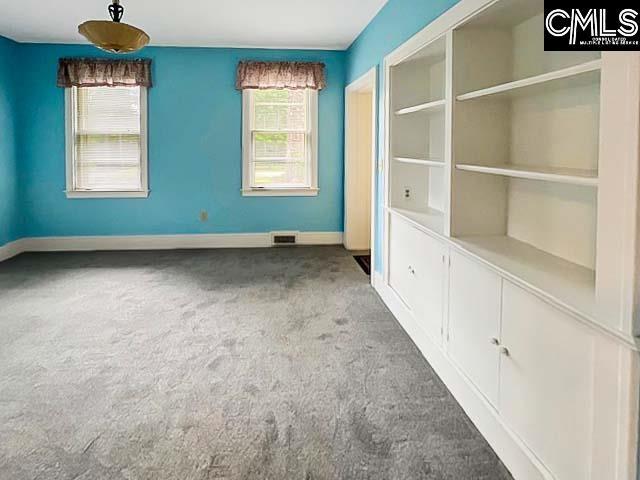 carpeted spare room featuring plenty of natural light