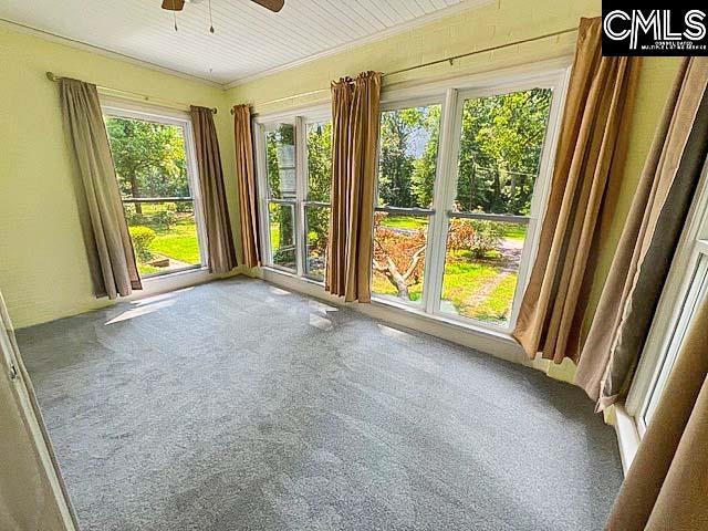 unfurnished sunroom featuring ceiling fan