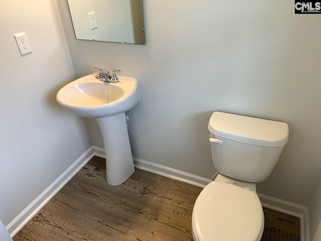 bathroom with hardwood / wood-style flooring and toilet