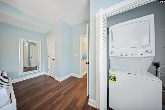 laundry area featuring dark wood-type flooring and stacked washer / dryer