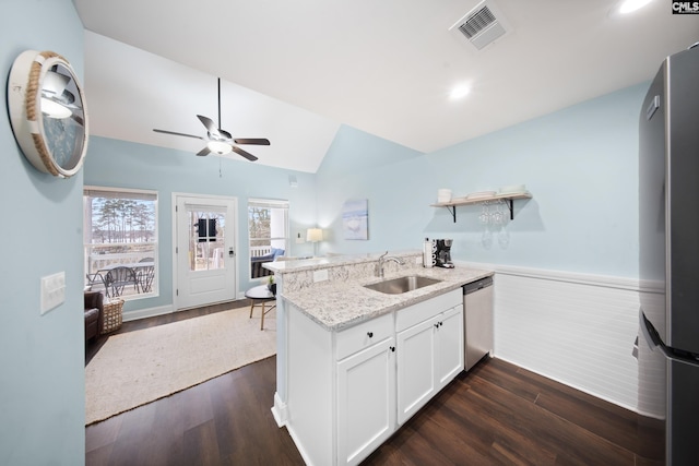 kitchen with sink, white cabinets, kitchen peninsula, stainless steel appliances, and light stone countertops