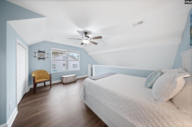 bedroom with ceiling fan, dark hardwood / wood-style flooring, vaulted ceiling, and a closet